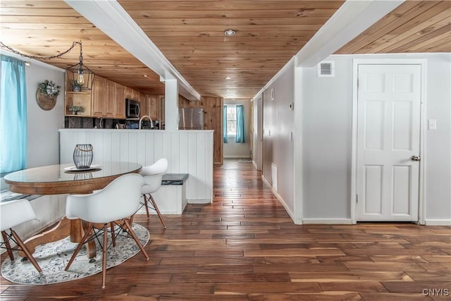 dining space with visible vents, baseboards, wood ceiling, and dark wood-style floors