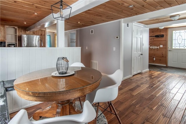 dining area featuring visible vents, wooden ceiling, baseboards, and wood finished floors