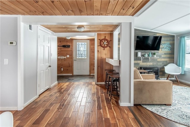 foyer featuring visible vents, a healthy amount of sunlight, wood finished floors, and wooden ceiling