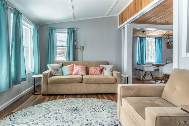 living room featuring lofted ceiling, crown molding, baseboards, and wood finished floors