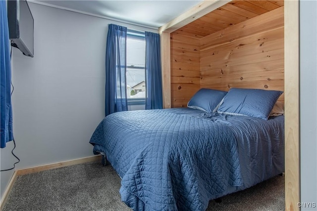 bedroom with wooden walls, carpet flooring, and baseboards