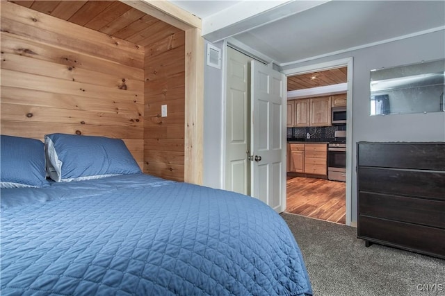 bedroom featuring wooden walls, wood ceiling, visible vents, and dark carpet