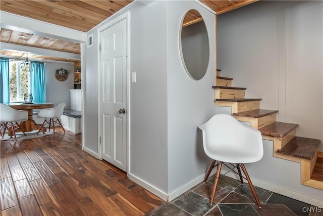 interior space with baseboards, stairway, beam ceiling, wooden ceiling, and dark wood-style floors