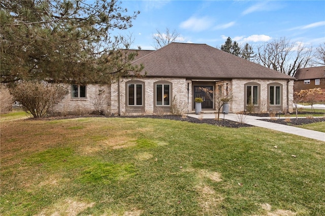 view of front facade with a front lawn, brick siding, and a shingled roof