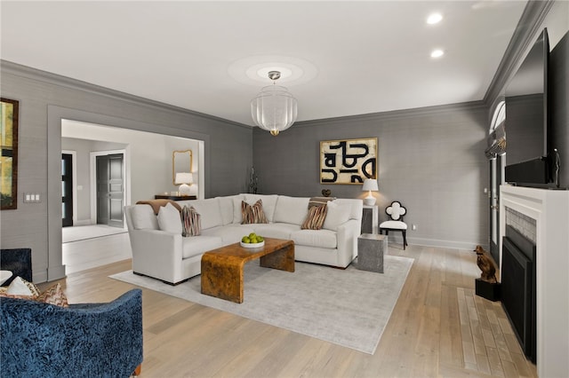 living room featuring a fireplace with flush hearth, light wood-style flooring, ornamental molding, recessed lighting, and baseboards