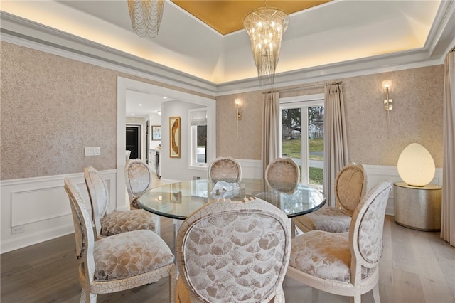 dining area featuring wallpapered walls, crown molding, light wood-type flooring, and wainscoting