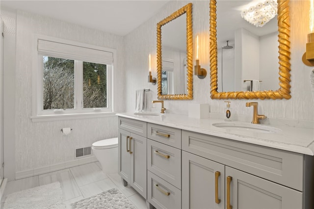 full bath featuring double vanity, visible vents, toilet, and a sink