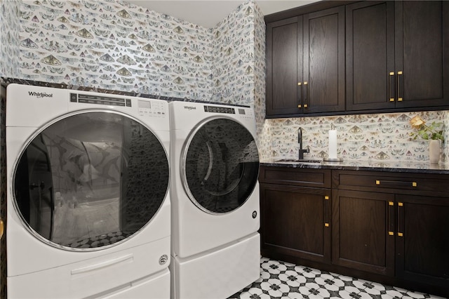 clothes washing area with light floors, wallpapered walls, cabinet space, a sink, and independent washer and dryer