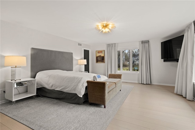 bedroom featuring visible vents, baseboards, and light wood-style flooring