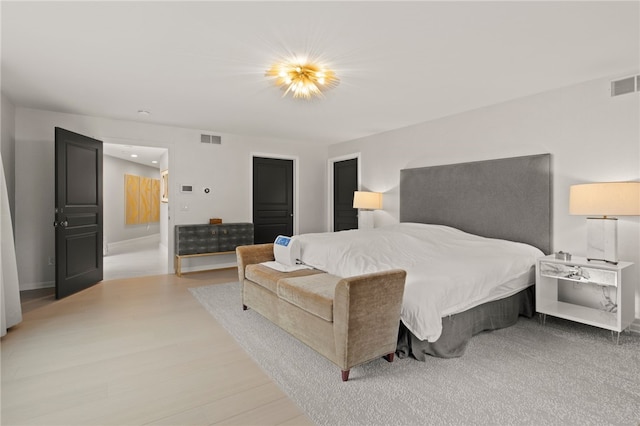 bedroom featuring wood finished floors and visible vents