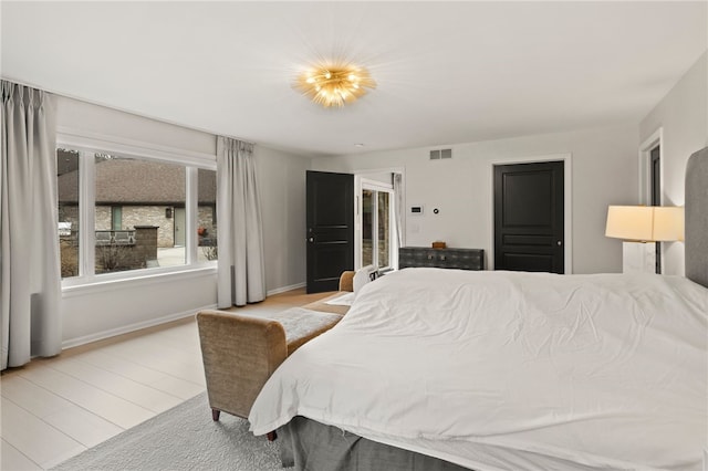 bedroom featuring visible vents, baseboards, and wood finished floors