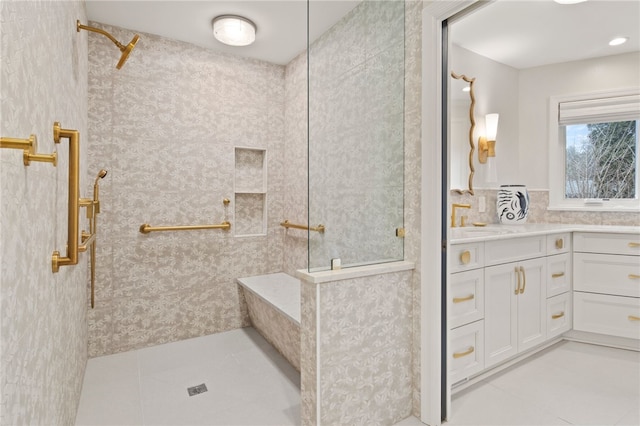 bathroom featuring tile patterned flooring, vanity, and a walk in shower