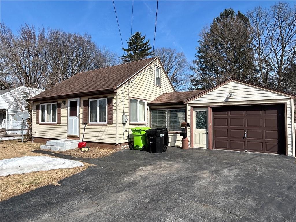 view of front of home with aphalt driveway and roof with shingles