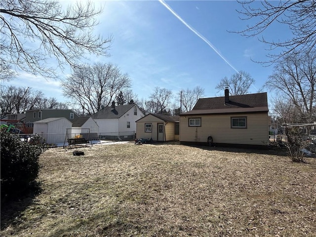 rear view of property featuring fence and a chimney