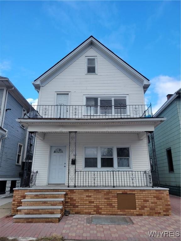 view of front facade with a balcony and covered porch