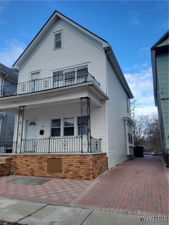 view of front facade featuring a balcony and covered porch