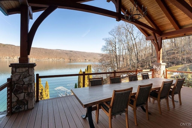 wooden deck featuring outdoor dining area and a water view