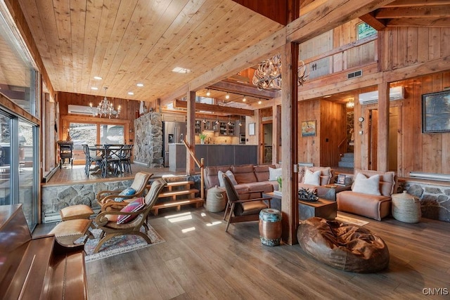 living area with wooden walls, wood finished floors, high vaulted ceiling, wooden ceiling, and a chandelier