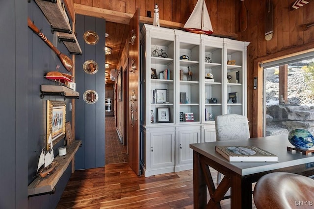 dining room with wood finished floors and wood walls