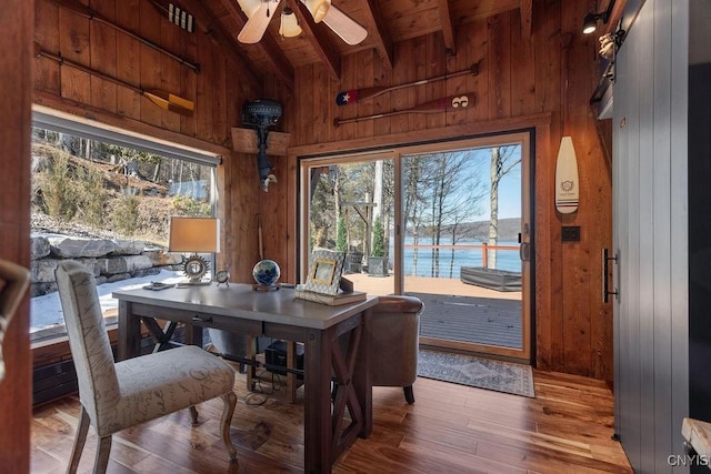 dining room featuring lofted ceiling with beams, wood finished floors, wood ceiling, and wood walls