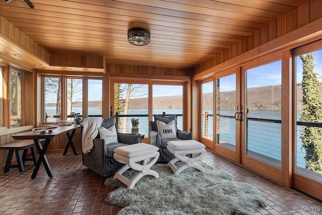 sunroom / solarium with wooden ceiling and a water view