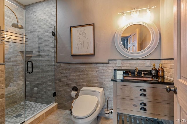 full bathroom featuring a wainscoted wall, vanity, toilet, and a shower stall