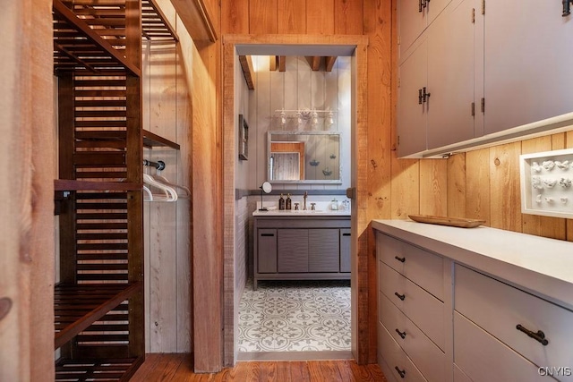 interior space with wooden walls, a sauna, vanity, and wood finished floors