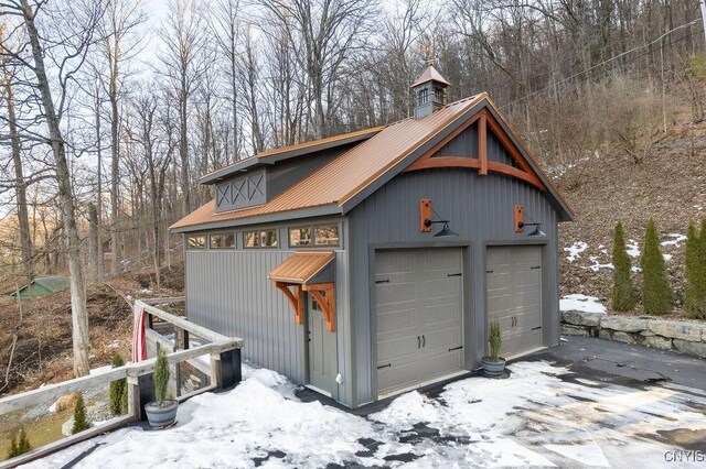 snow covered garage with a detached garage