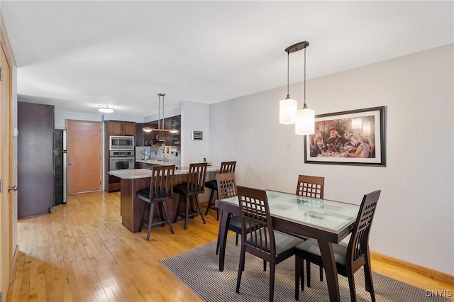 dining room featuring baseboards and light wood-style floors