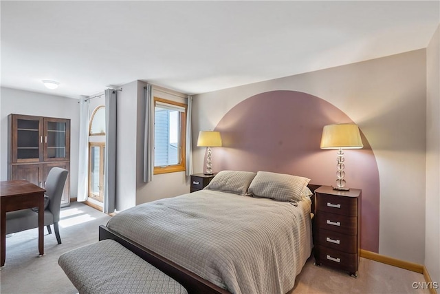 bedroom with light colored carpet and baseboards