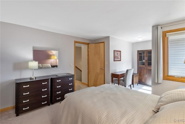 bedroom with baseboards and light carpet