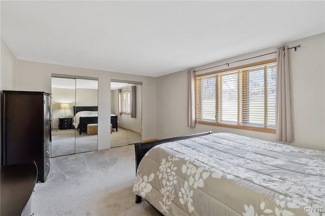 bedroom with baseboards, multiple closets, and carpet floors