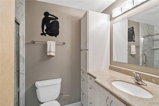 bathroom with vanity, toilet, and a shower with shower door