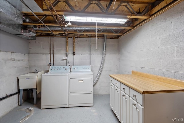 clothes washing area featuring washer and clothes dryer and cabinet space