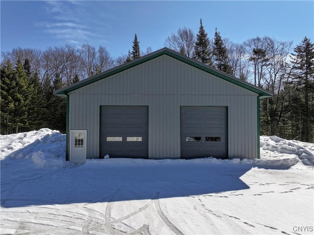 snow covered garage featuring a detached garage