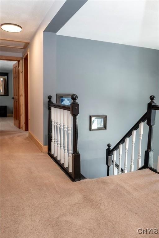 staircase featuring baseboards and carpet flooring