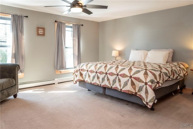 carpeted bedroom with a baseboard heating unit, multiple windows, and a ceiling fan