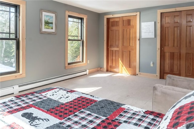 bedroom with baseboards, baseboard heating, and carpet flooring