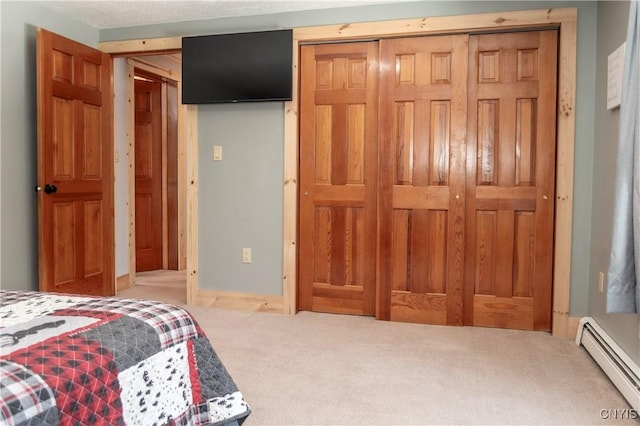 bedroom featuring carpet, a closet, and baseboard heating