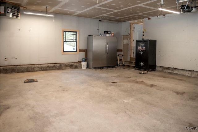 garage with a garage door opener and freestanding refrigerator