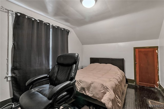 bedroom featuring dark wood finished floors and vaulted ceiling