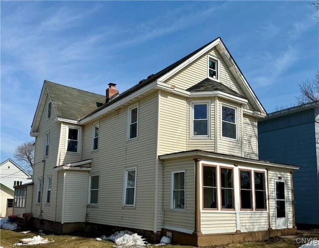 rear view of property featuring a chimney