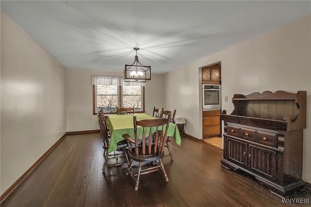 dining area with a chandelier, dark wood-type flooring, and baseboards