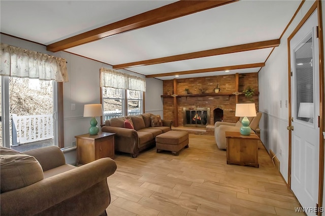 living room with beam ceiling, light wood-style flooring, and a fireplace