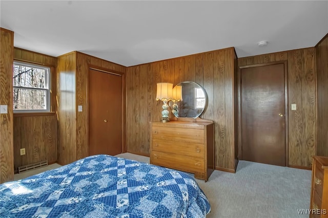 carpeted bedroom featuring baseboard heating and wood walls