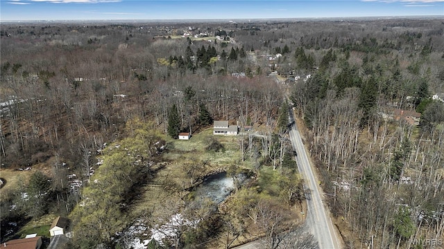 birds eye view of property featuring a wooded view