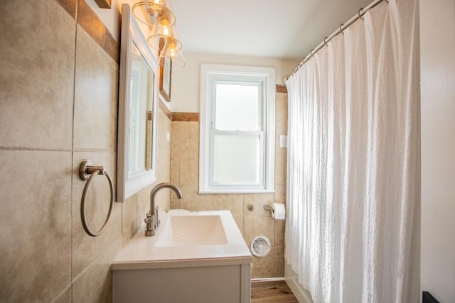 bathroom with vanity and tile walls