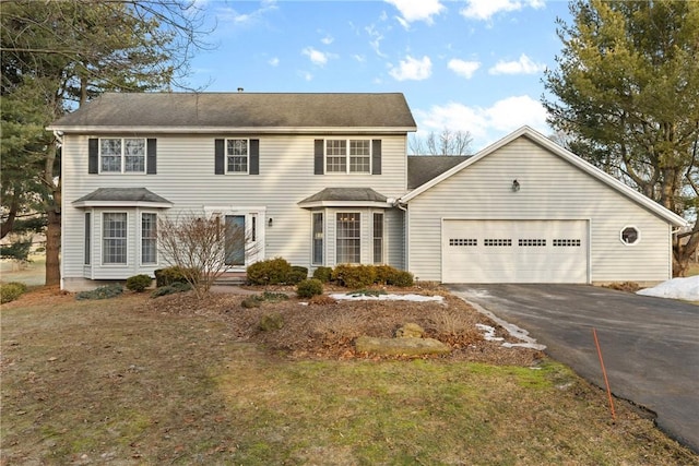 colonial house featuring driveway and an attached garage