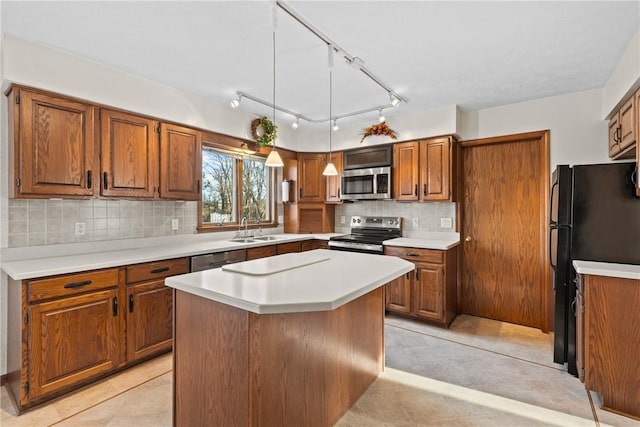 kitchen with brown cabinetry, appliances with stainless steel finishes, tasteful backsplash, and a sink