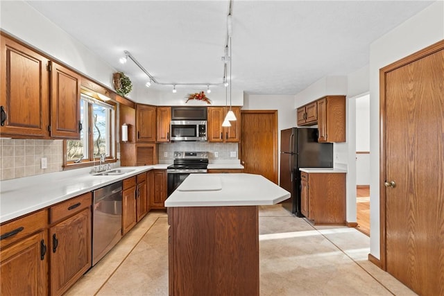 kitchen with a kitchen island, a sink, stainless steel appliances, brown cabinets, and backsplash